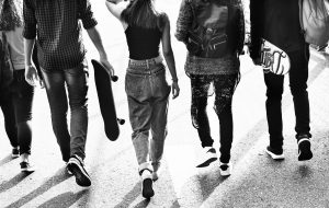 Schwarz-Weiß Foto einer Gruppe Jugendlicher mot Skateboards von hinten